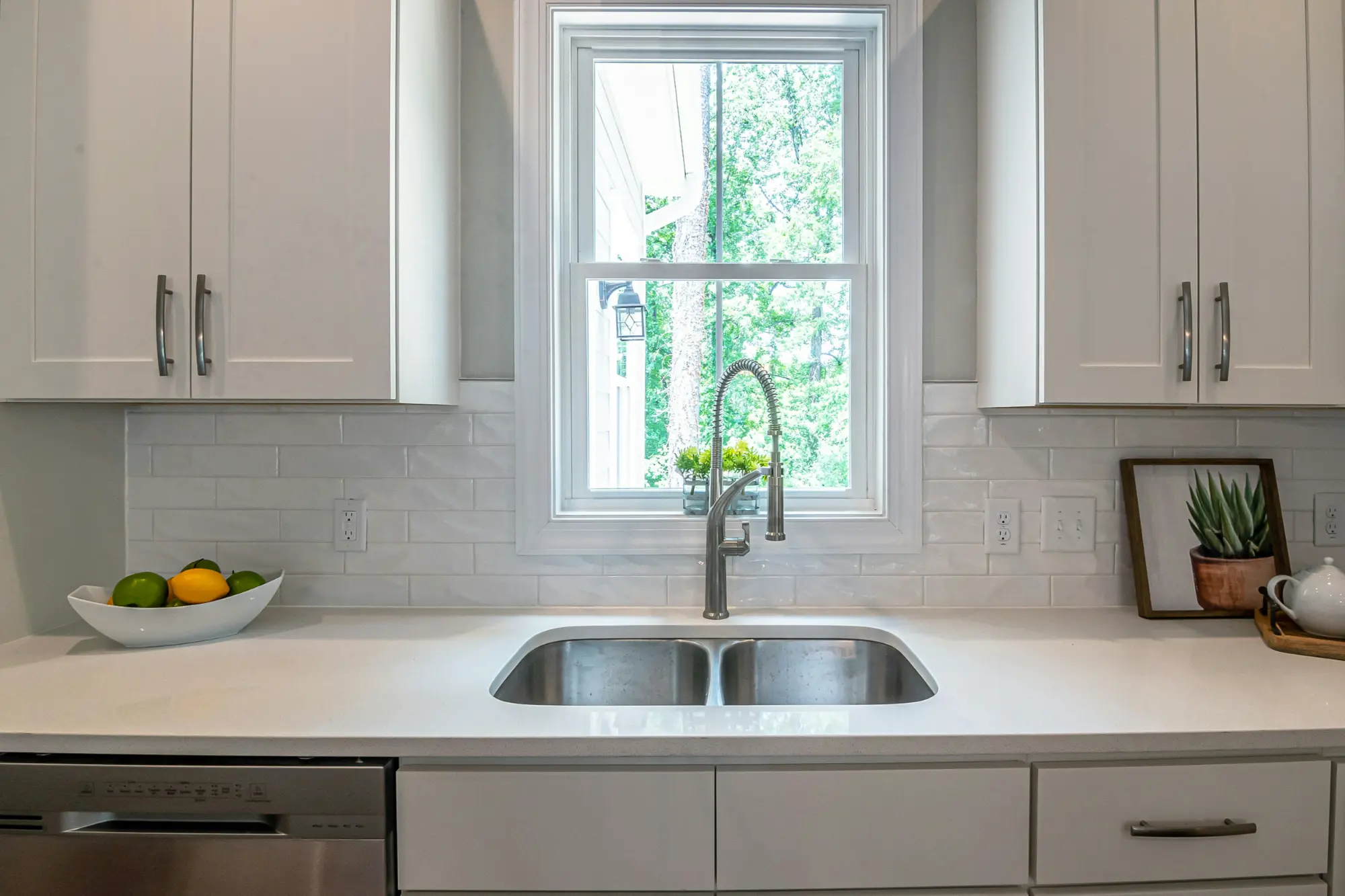 image of a kitchen sink with faucet and window for topic about choosing the right backsplash design