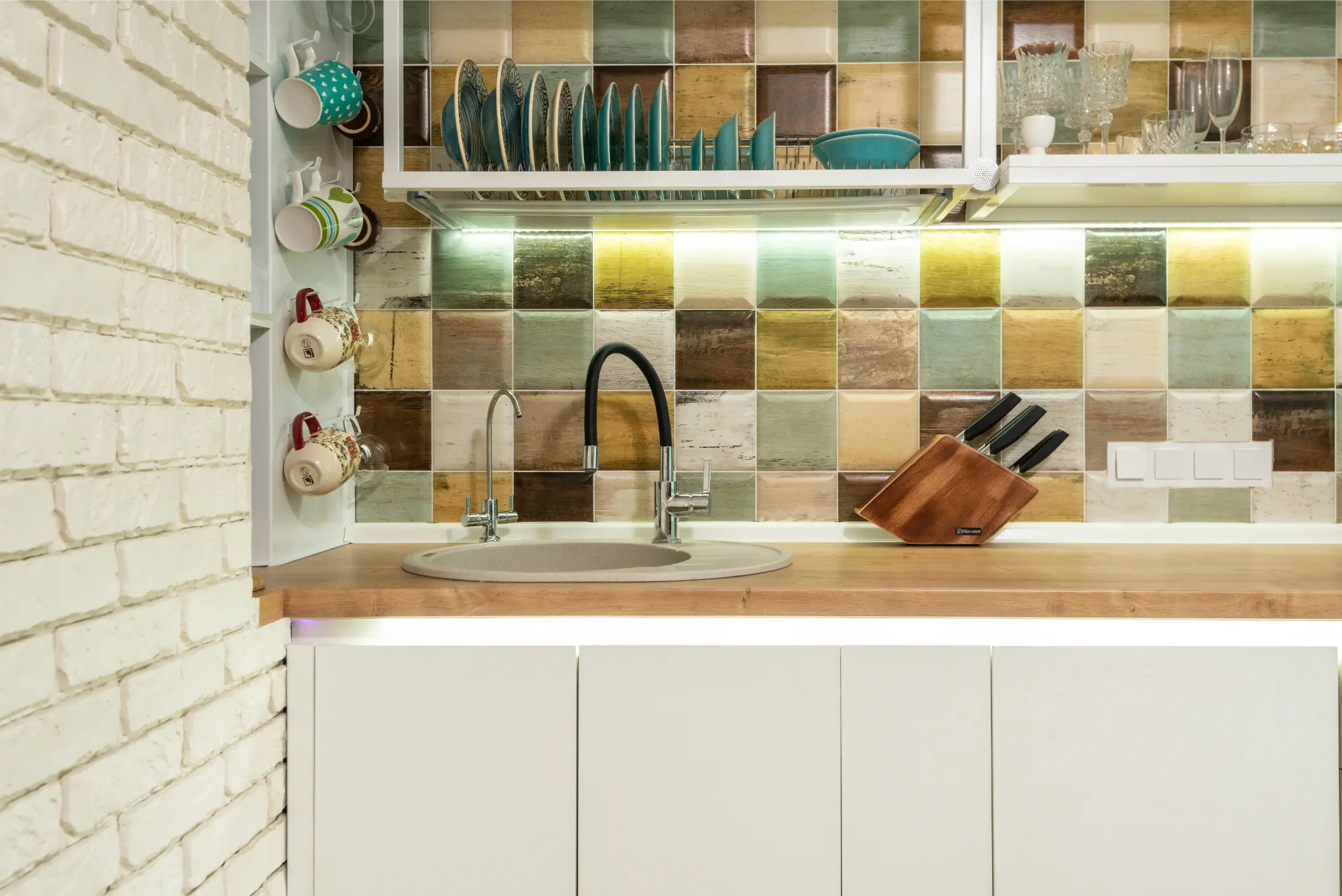 kitchen sink with utensils and bright colorful backsplash
